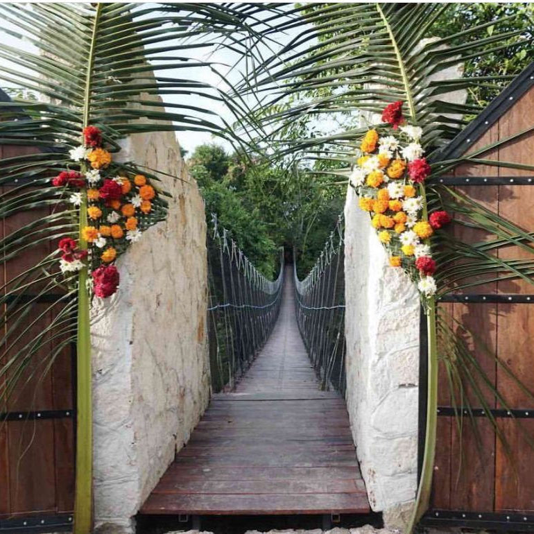 Decorative wooden gates with floral arrangements on a suspension bridge